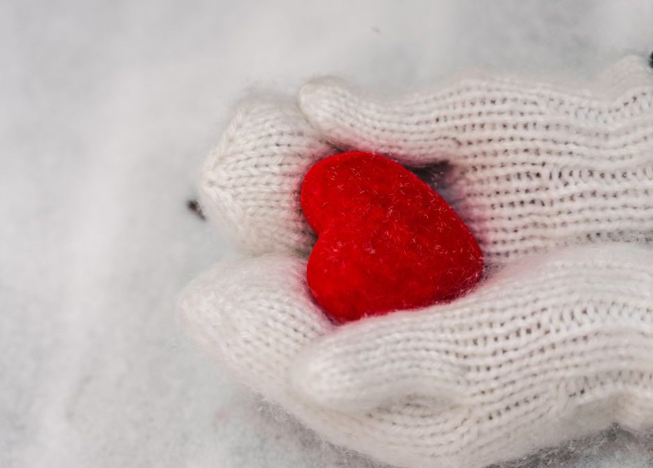 Mittened hands holding small red heart